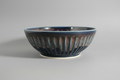 Ceramic bowl with a textured surface on a dark surface, with smartphone interface at the bottom.