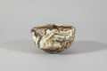Small ceramic bowl with a matte surface on marbled clay