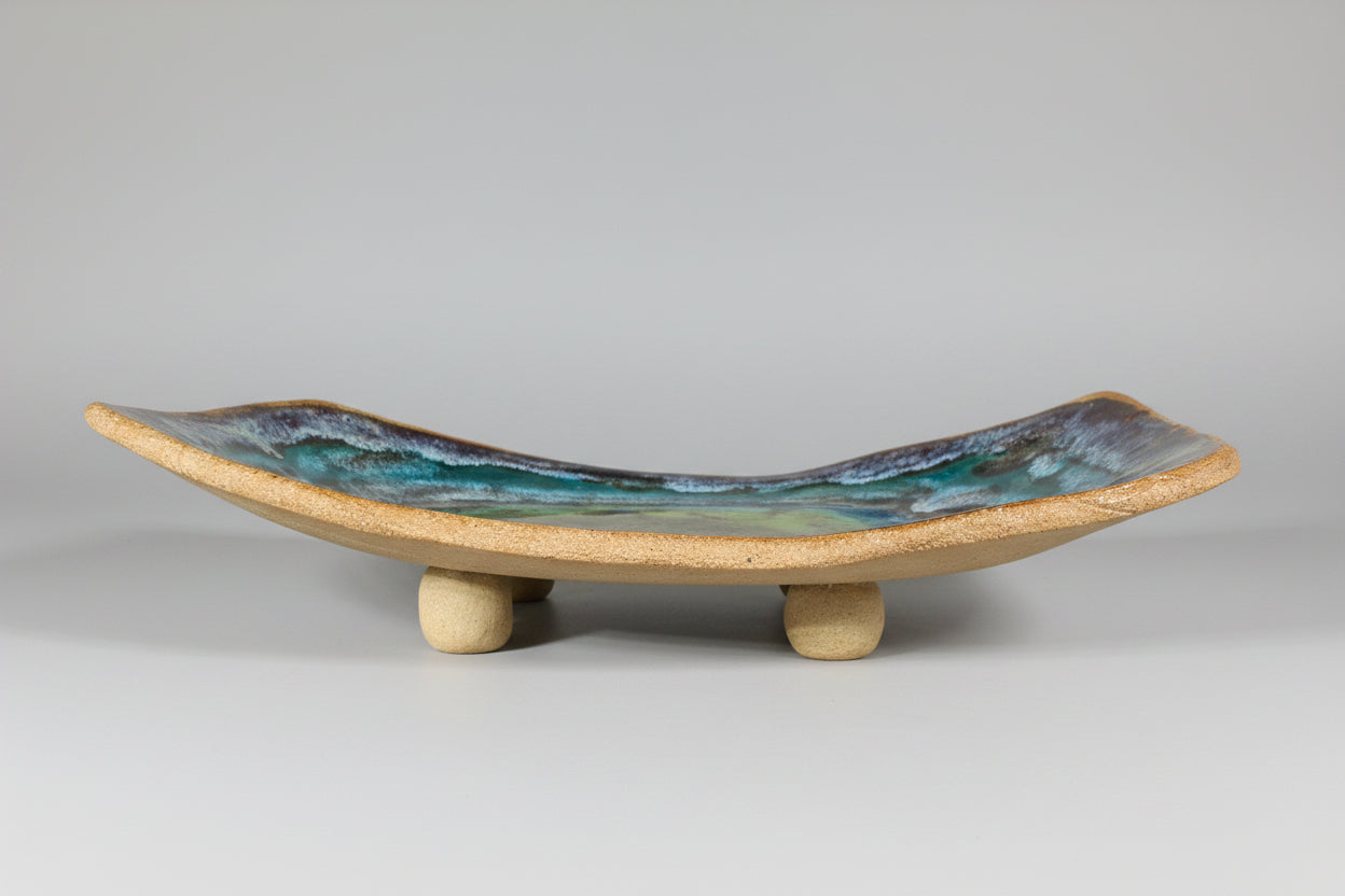 Ceramic dish with a raw edge base on a brown clay