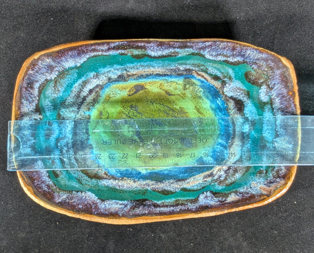 Geode type of glaze with concentric layers of green and brown on a black background