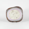 Decorative plate with a speckled center on a dark background