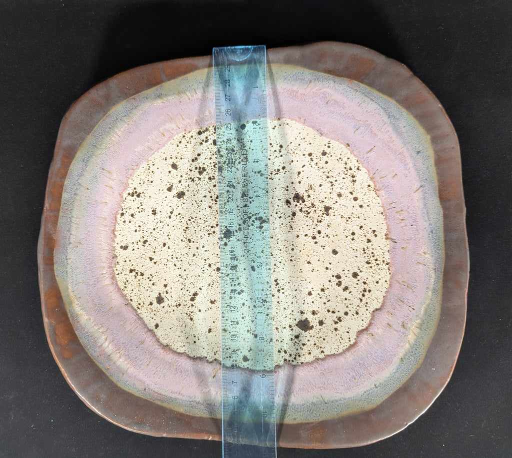 Ceramic plate with a central band of color on a black background