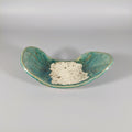 Teal ceramic dish with textured surface on a white background