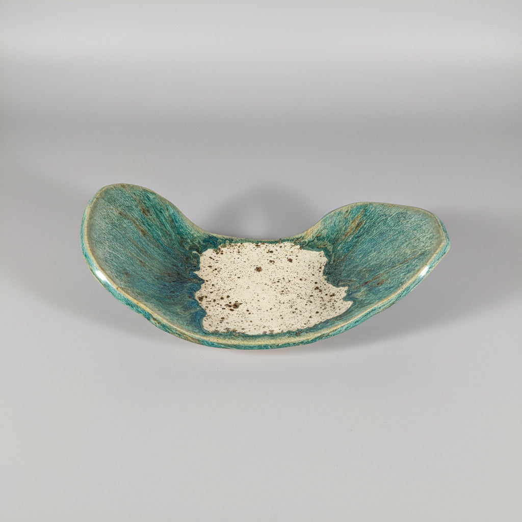 Teal ceramic dish with textured surface on a white background